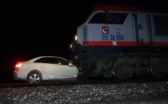 Trenin altında kalan otomobildeki 2 kişi ölümden döndü
